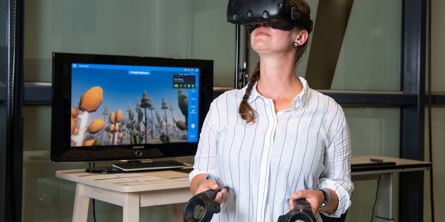 Kvinde iført VR-briller og med controllere i hænderne