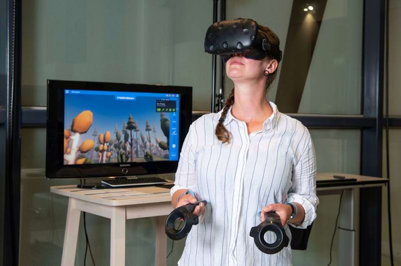Kvinde iført VR-briller og med controllere i hænderne